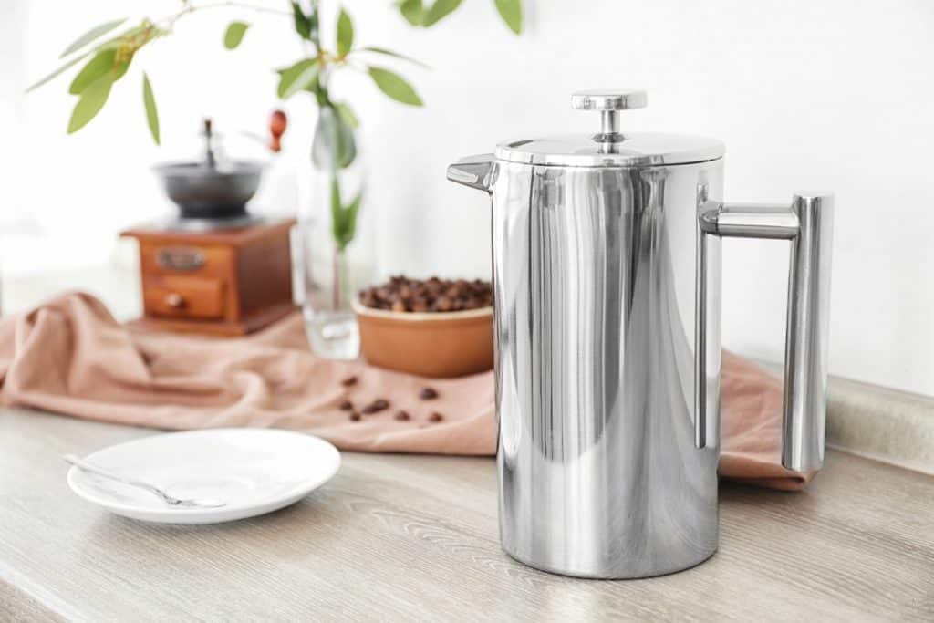 Stainless steel coffee press on table