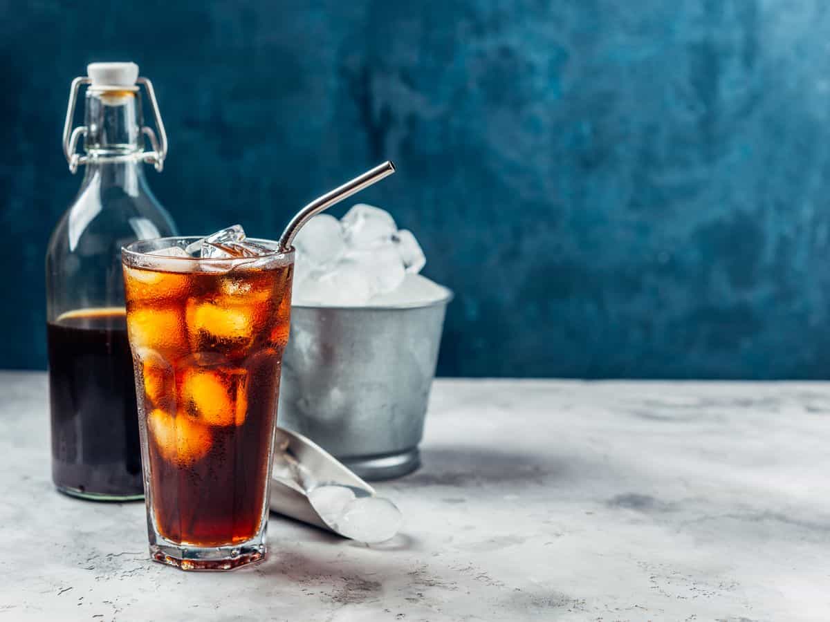 Black cold brew coffee in a glass with metal straw