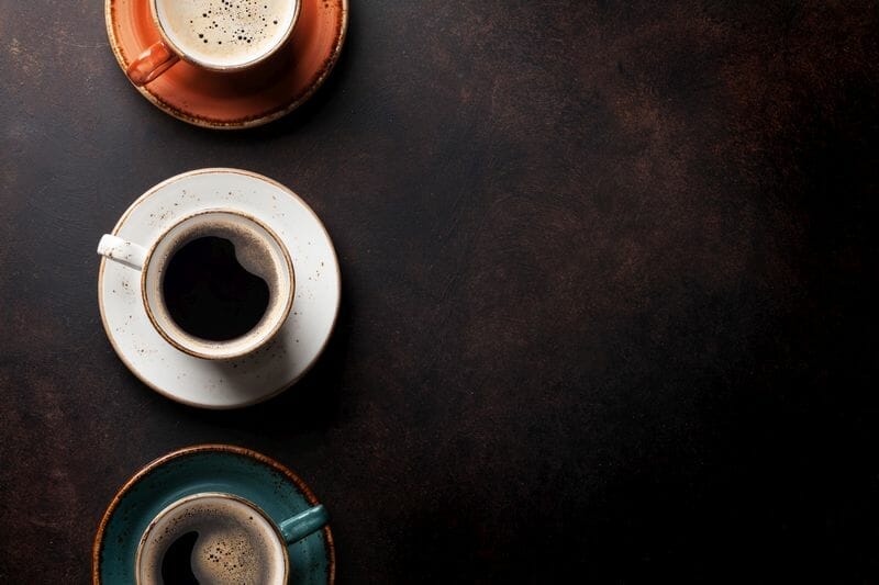 3 coffee cups on dark background