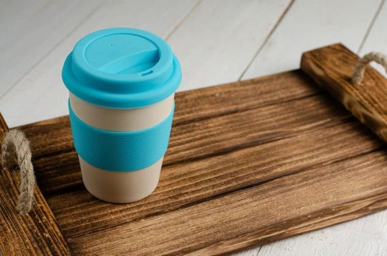 eco friendly bamboo coffee cup on wooden tray