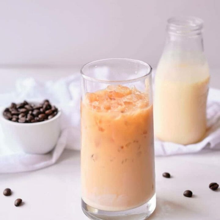 Glass of Vietnamese style iced coffee with condensed milk in jar