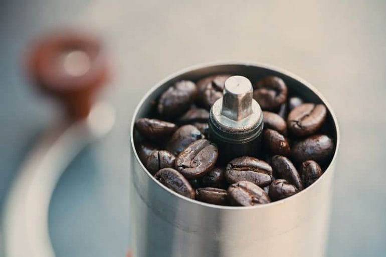 Coffee beans in a hand grinder closeup