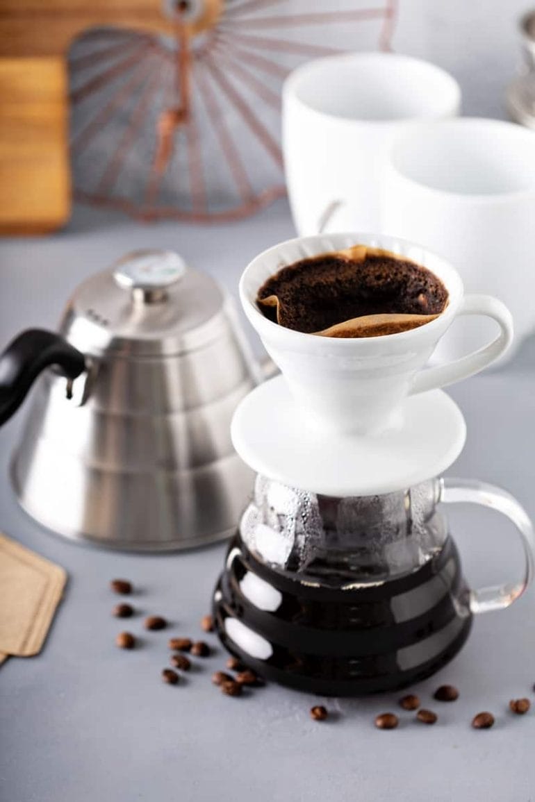 Pour over coffee being made with a gooseneck kettle and glass carafe