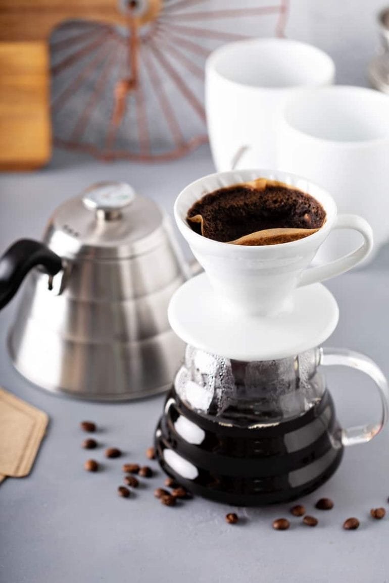Pour over coffee being made with a gooseneck kettle and glass carafe