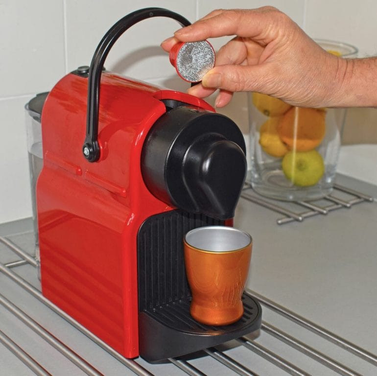 Preparing a coffee with a pod coffee machine and coffee pod.
