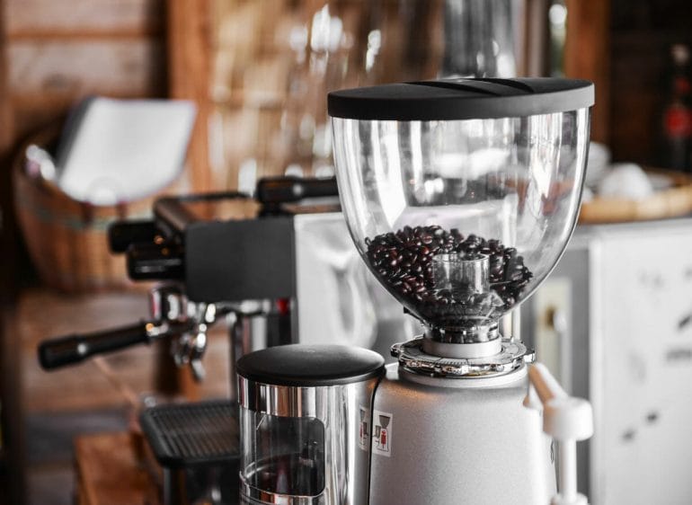 Large electric coffee grinder next to espresso machine
