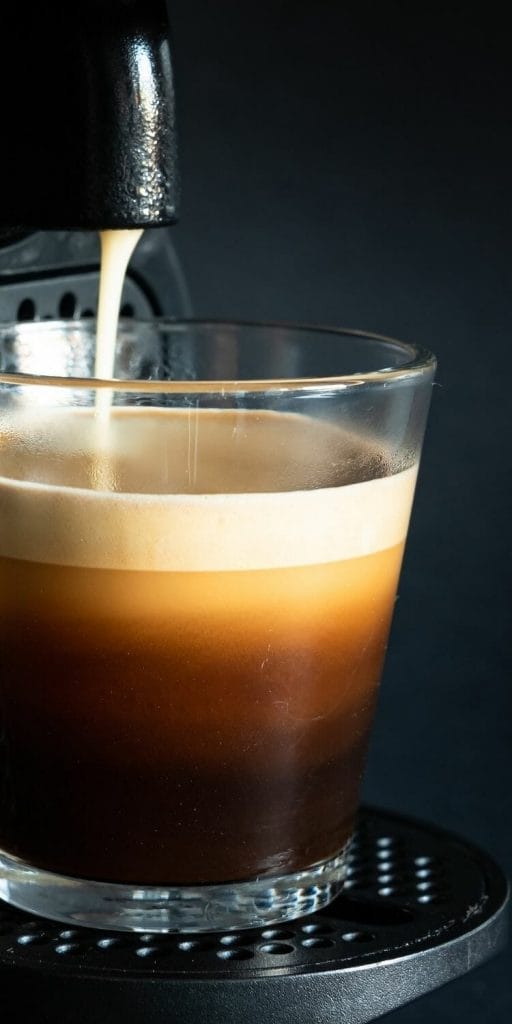 Nespresso coffee machine pouring espresso into glass