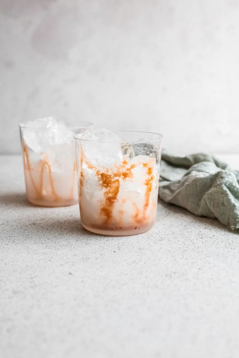Glass with ice and salted caramel sauce on inside.