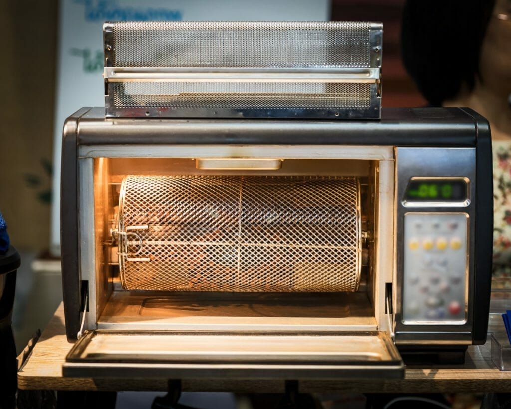 Home coffee roaster in action roasting coffee beans.