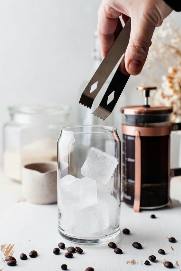 Glass filled with ice cubes - process step for coconut cold brew recipe.