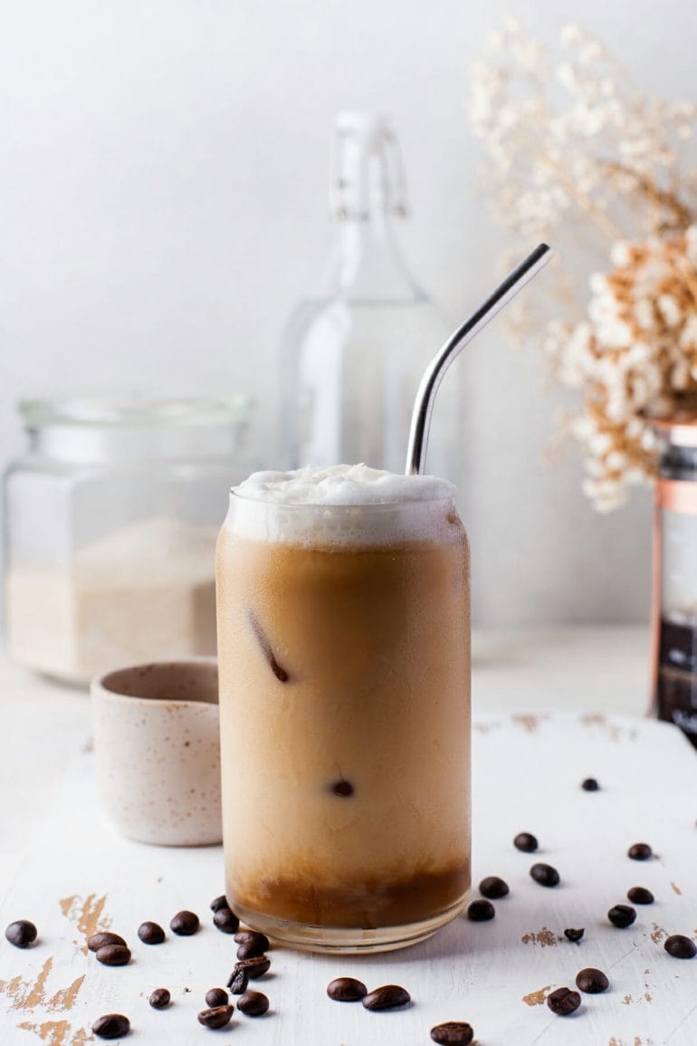 cold brew coffee made with coconut milk in glass with metal straw.