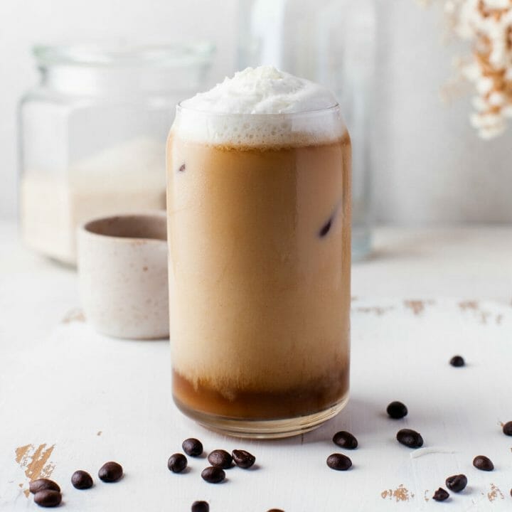 iced cold brew with coconut milk in glass with coconut milk foam.
