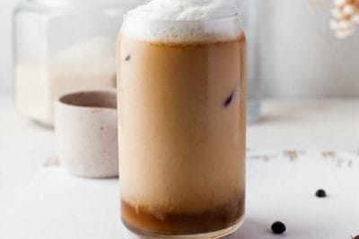 iced cold brew with coconut milk in glass with coconut milk foam.