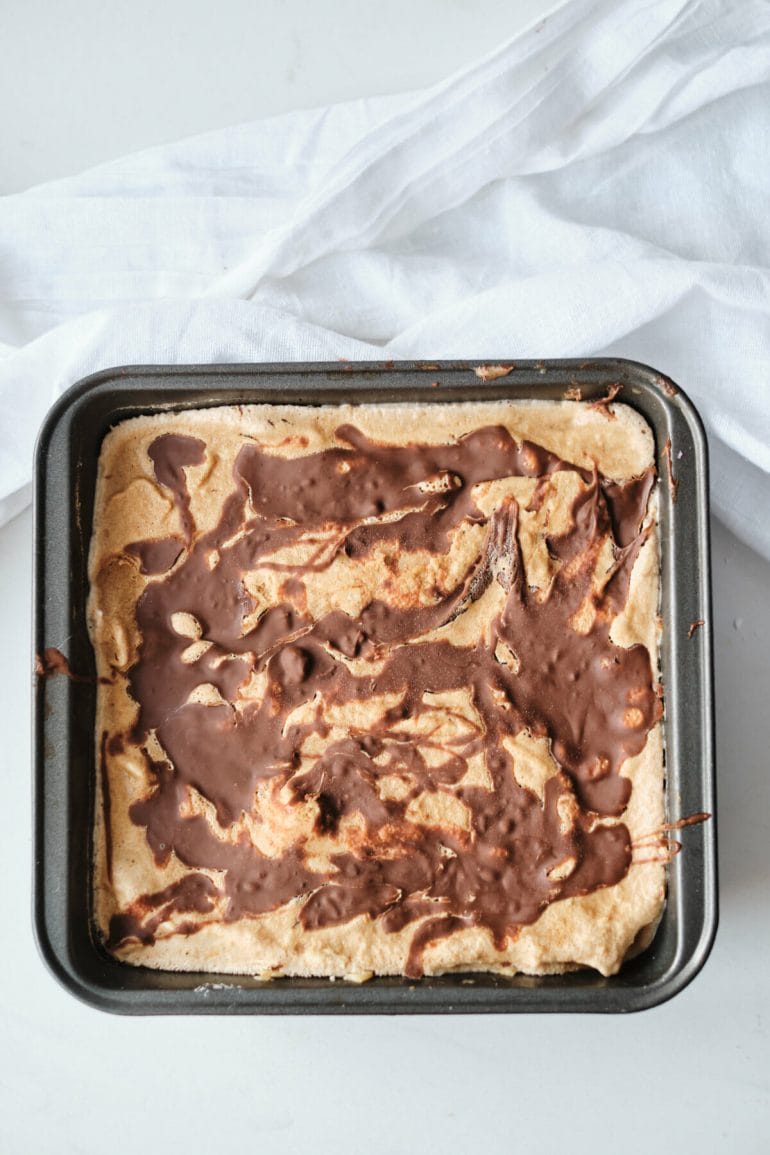 Process shot of coffee ice cream with nutella swirl in tin.